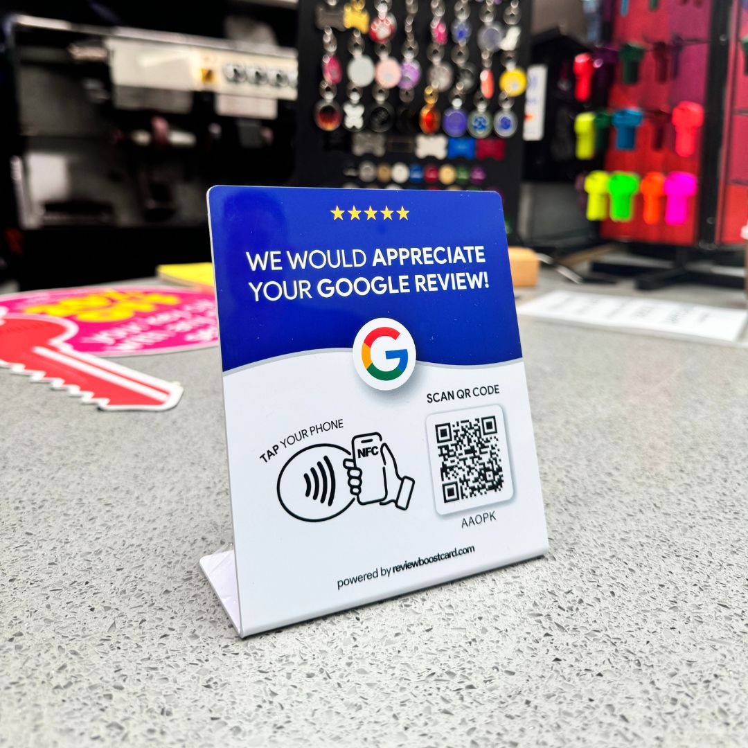 Google ReviewBoost stand displayed on a small business counter, inviting customers to easily leave a Google review by hovering their phone near the stand, enhancing the business's online visibility and customer engagement.