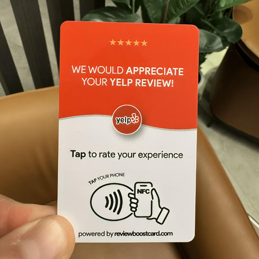 A single Yelp review card held in a person's hand, showing the front with the NFC-enabled review request and the back with a QR code