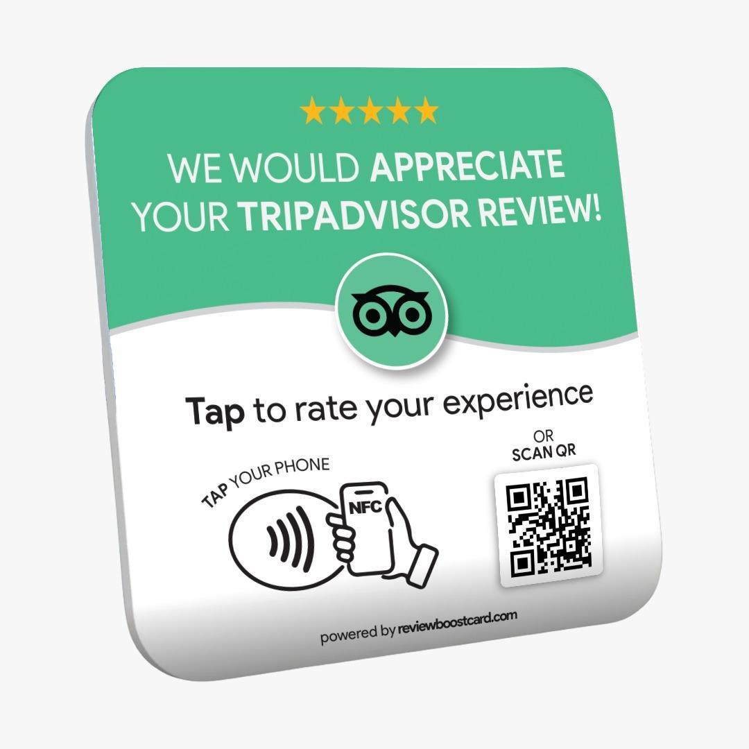 A ReviewBoost plaque requesting a TripAdvisor review. The plaque is green and white with the TripAdvisor logo and text that says, 'We would appreciate your TripAdvisor review! Tap to rate your experience. Tap your phone or scan QR